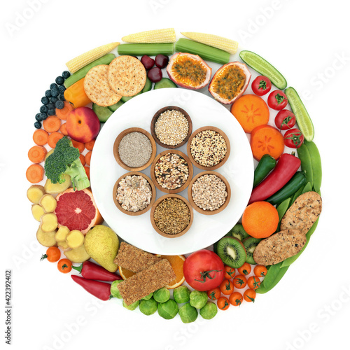Healthy high fibre food collection for good digestive health on & around a white plate with foods also high in antioxidants, minerals, vitamins, anthocyanins, omega 3 & protein. On white.