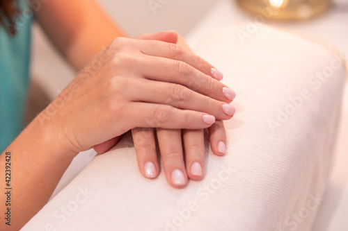 manicurist holds hands of the client in beauty salon. manicure in the salon