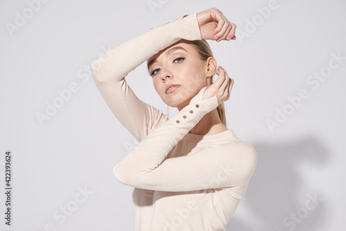 Pretty model in beige blouse and jeans. Glow makeup, healthy skin and so natural.