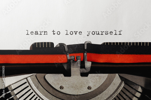 Text Learn to love yourself typed on retro typewriter
