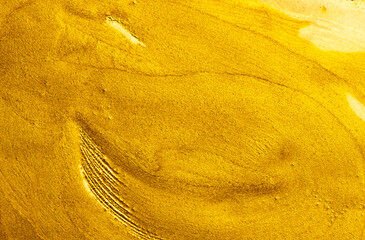 Beautiful abstract golden liquid paint background, beauty gold backdrop texture. Metallic gold paint, art design. Yellow shimmering surface close-up. Golden bright glitter texture, macro shot 
