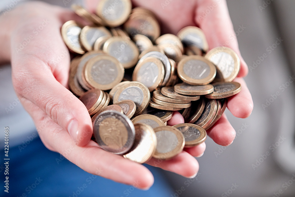 Savings, close up of cupped female hands holding golden coins Savings, close up of cupped female hands holding golden coins