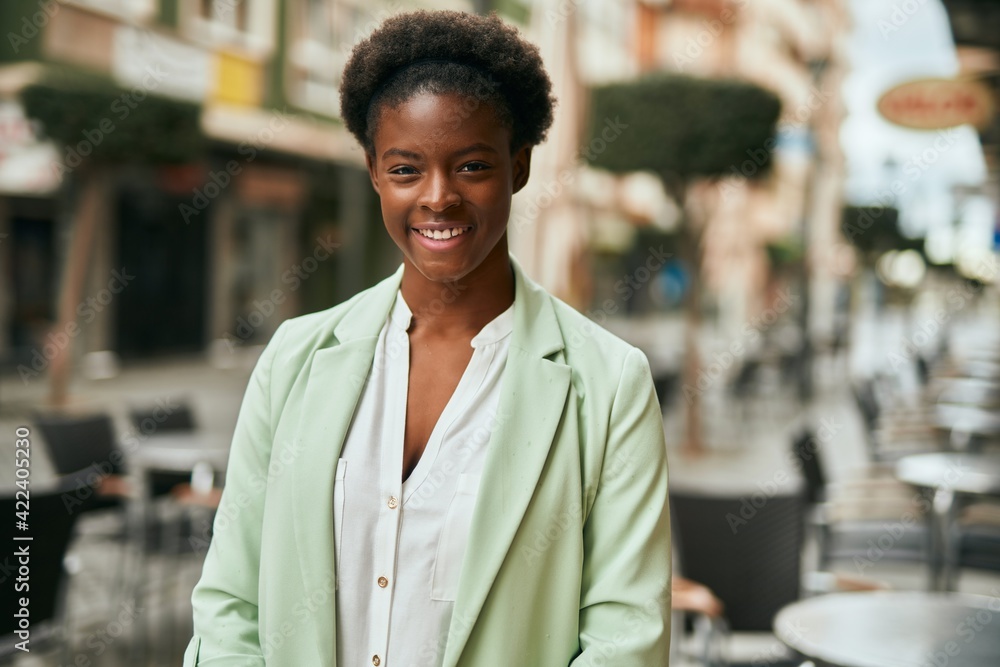 Fototapeta premium Young african american businesswoman smiling happy standing at the city