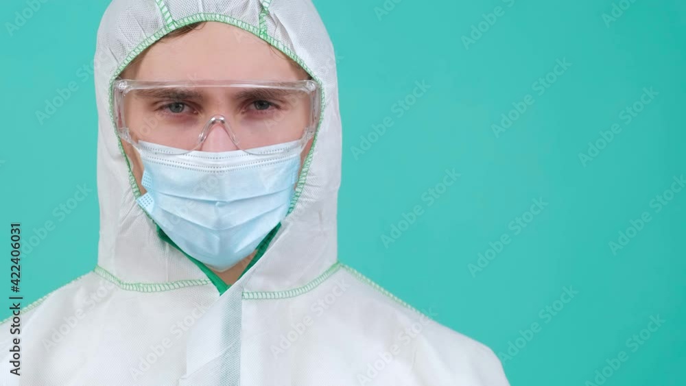 Man in protective suit, medical mask and goggles, looking at camera. Man in protective suit, medical mask and goggles, looking at camera.