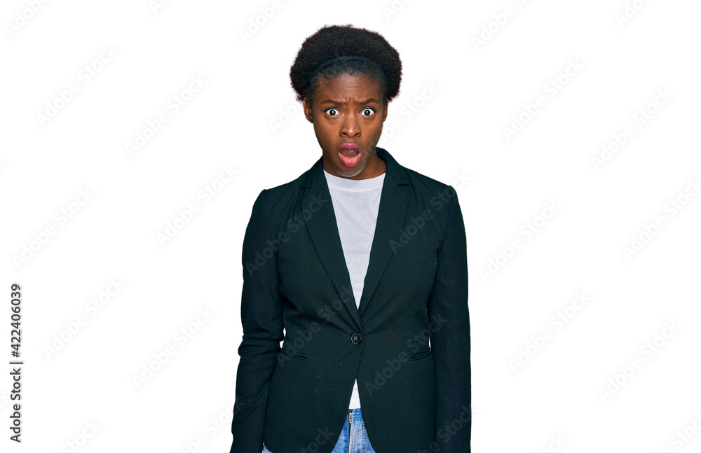 Young african american girl wearing business clothes in shock face, looking skeptical and sarcastic, surprised with open mouth Young african american girl wearing business clothes in shock face, looking skeptical and sarcastic, surprised with open mouth