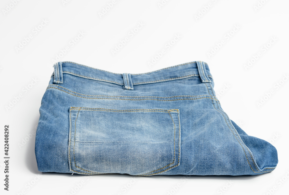 folded blue men's jeans on a white background folded blue men's jeans on a white background