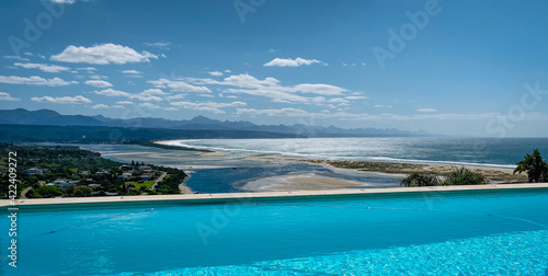Panoramic view over Plettenberg Bay and Keurboomsrivier, South Africa with pool in foreground.
