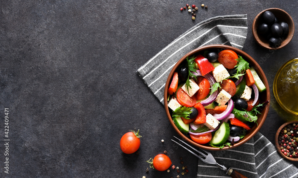 Classic Greek salad with feta and olives on a concrete background.