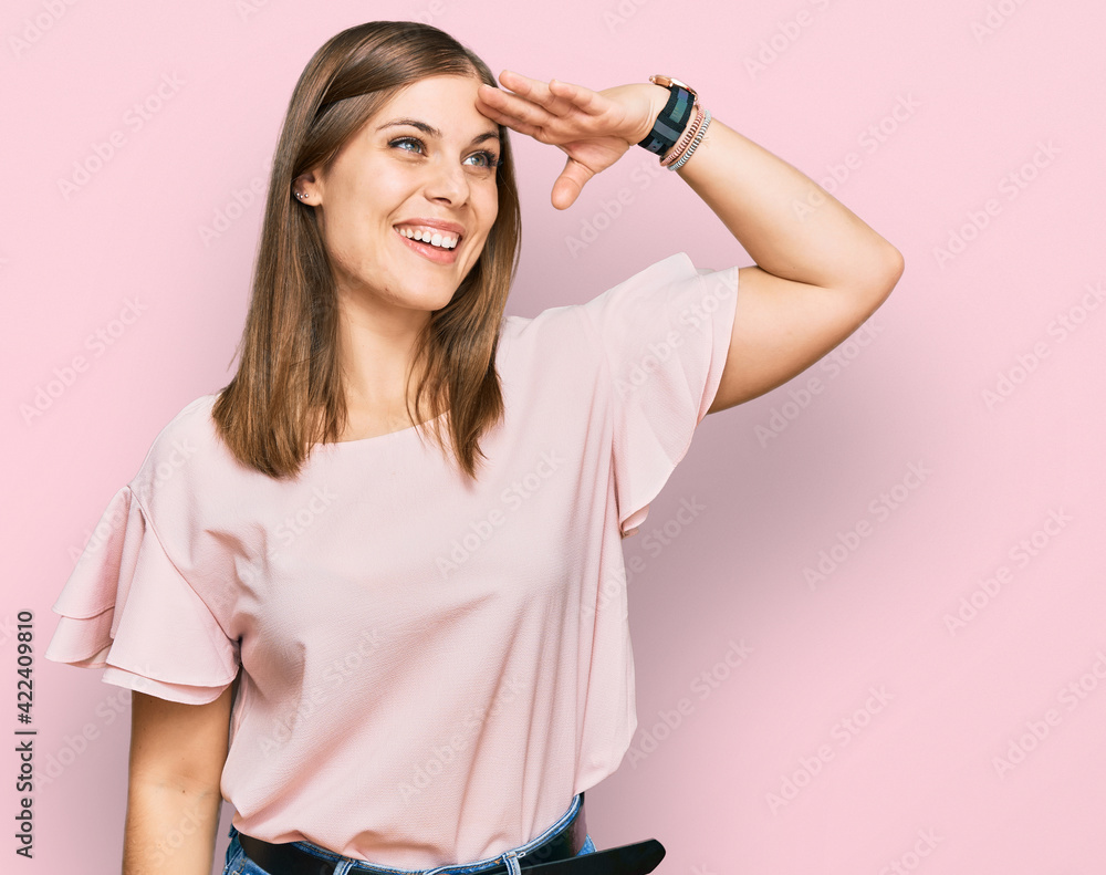 Beautiful caucasian woman wearing casual clothes very happy and smiling looking far away with hand over head. searching concept. Beautiful caucasian woman wearing casual clothes very happy and smiling looking far away with hand over head. searching concept.