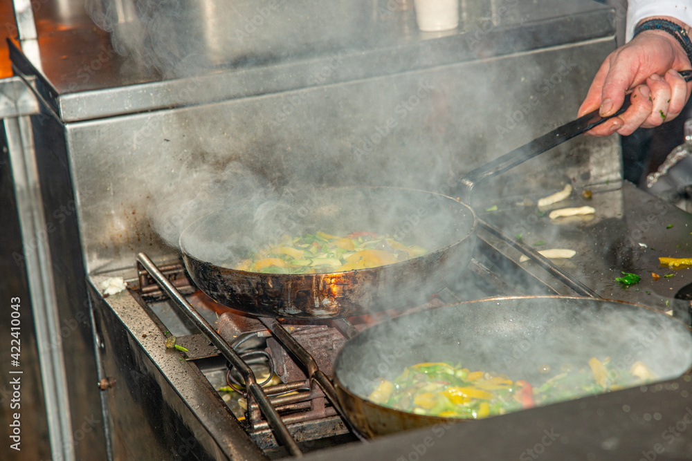 Cooking vegetable variety in a steaming hot frying pan preparing the base sauce for home made pasta meal. Greek cooking concept. Cooking vegetable variety in a steaming hot frying pan preparing the base sauce for home made pasta meal. Greek cooking concept.