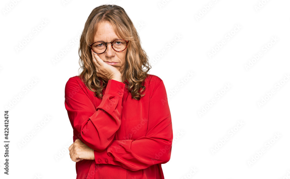 Middle age blonde woman wearing casual shirt over red background thinking looking tired and bored with depression problems with crossed arms. Middle age blonde woman wearing casual shirt over red background thinking looking tired and bored with depression problems with crossed arms.
