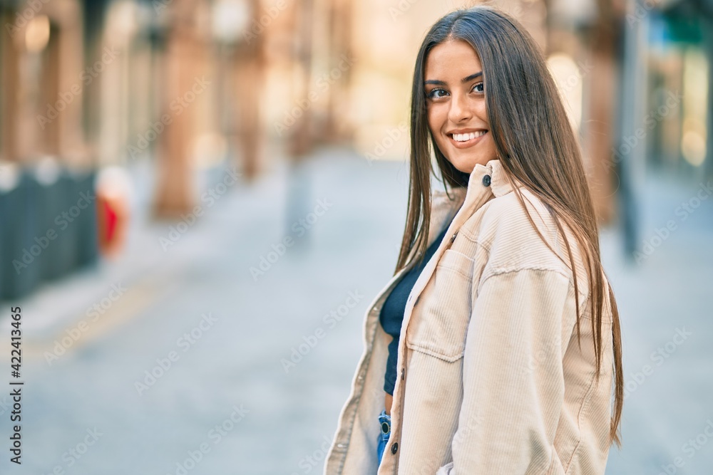 Young hispanic girl smiling happy standing at the city.