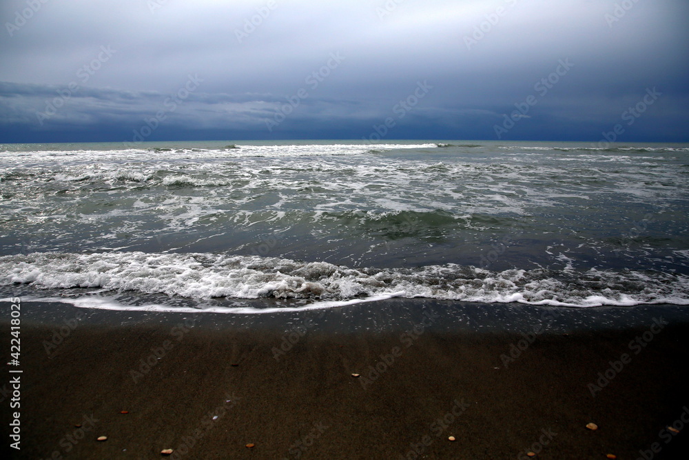 Close up of the movement of the waves breaking on the shore under the stormy sky Close up of the movement of the waves breaking on the shore under the stormy sky