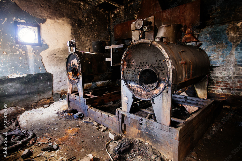 Old abandoned boiler room with rusty remnants of equipment