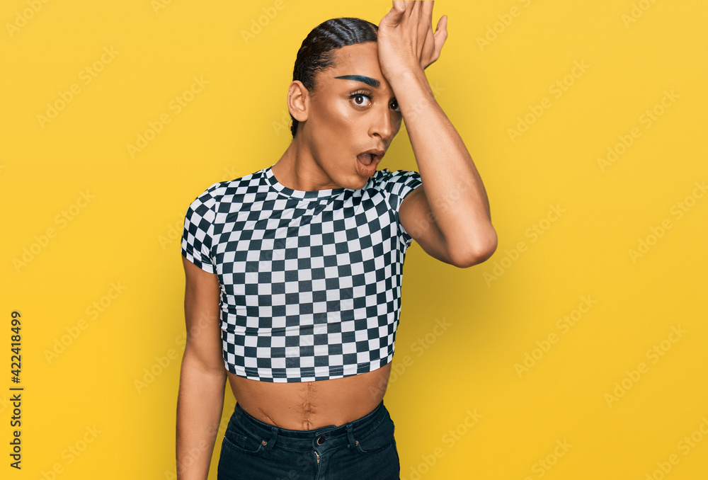 Hispanic transgender man wearing make up and long hair wearing modern clothes surprised with hand on head for mistake, remember error. forgot, bad memory concept. Hispanic transgender man wearing make up and long hair wearing modern clothes surprised with hand on head for mistake, remember error. forgot, bad memory concept.