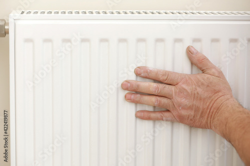 Wallpaper Mural Man in work overalls using wrench while installing heating radiator in room. plumber installing heating system in apartment. Concept of radiator installation, plumbing works and home renovation Torontodigital.ca