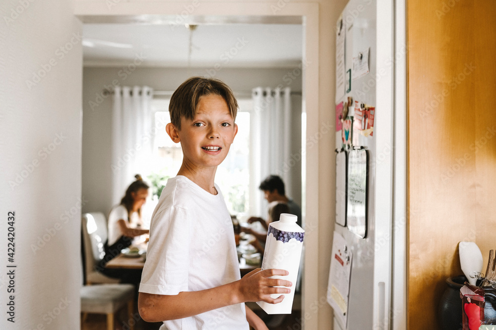 Boy with juice pack standing in kitchen Boy with juice pack standing in kitchen