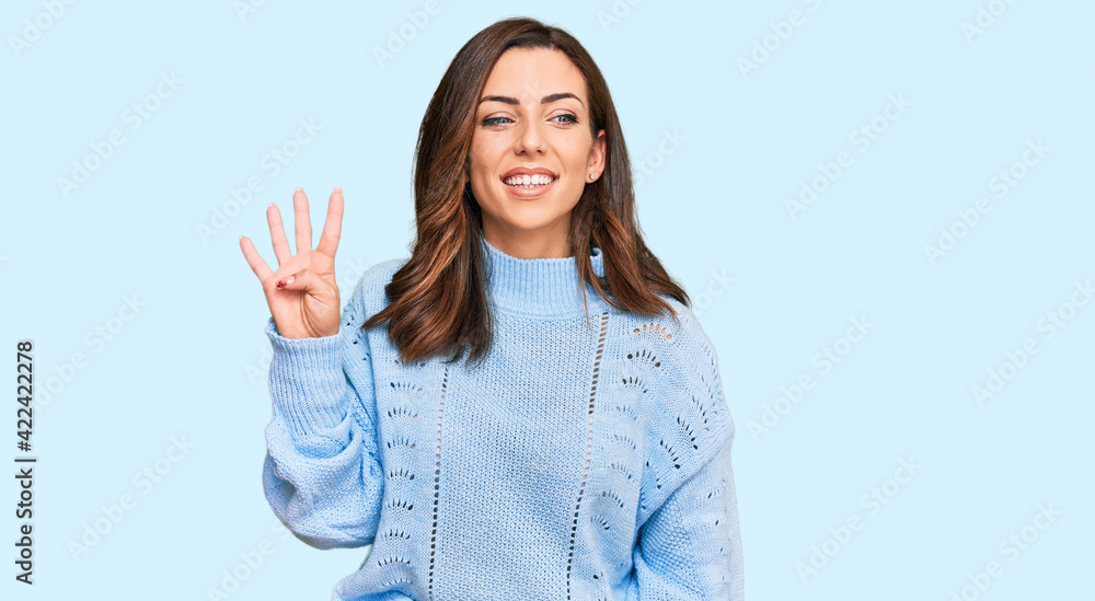 Young brunette woman wearing casual winter sweater showing and pointing up with fingers number four while smiling confident and happy. Young brunette woman wearing casual winter sweater showing and pointing up with fingers number four while smiling confident and happy.