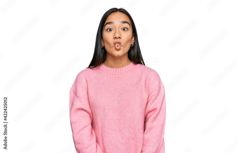 Young asian woman wearing casual winter sweater making fish face with lips, crazy and comical gesture. funny expression. Young asian woman wearing casual winter sweater making fish face with lips, crazy and comical gesture. funny expression.