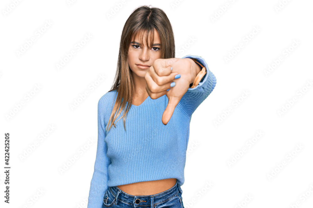 Teenager caucasian girl wearing casual clothes looking unhappy and angry showing rejection and negative with thumbs down gesture. bad expression. Teenager caucasian girl wearing casual clothes looking unhappy and angry showing rejection and negative with thumbs down gesture. bad expression.