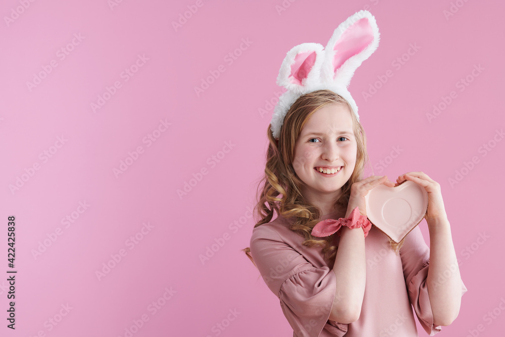 Portrait of smiling stylish child in pink dress on pink