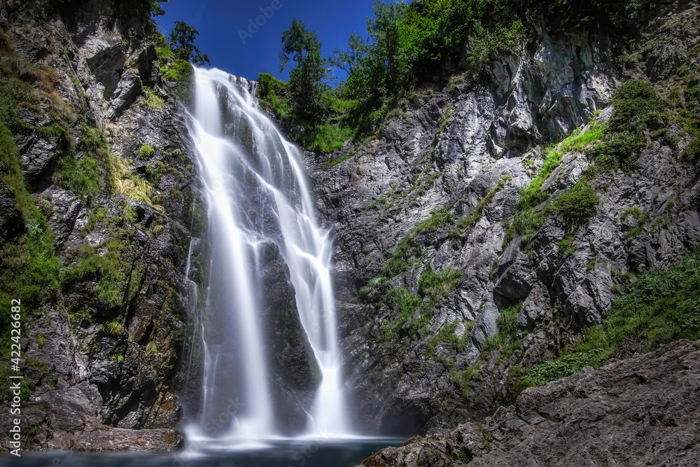 Obraz premium long daytime exposure of the huge waterfall of Saut deth Pish in the Aran Valley, Catalan Pyrenees, Lerida, Spain, vertical
