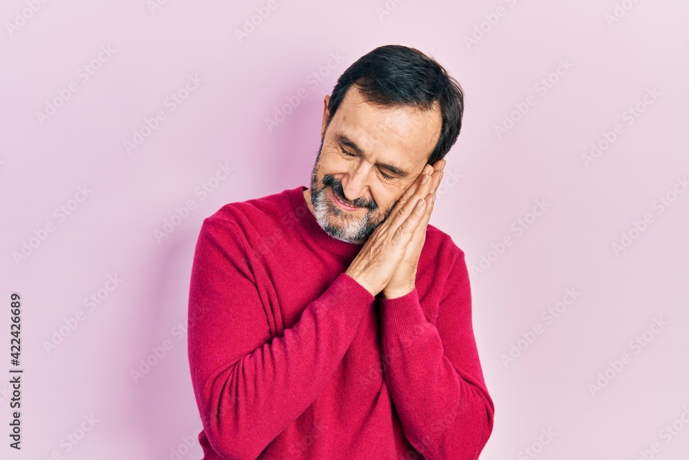 Middle age hispanic man wearing casual clothes sleeping tired dreaming and posing with hands together while smiling with closed eyes. Middle age hispanic man wearing casual clothes sleeping tired dreaming and posing with hands together while smiling with closed eyes.