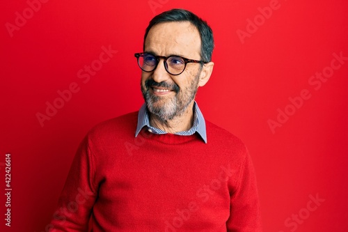 Middle age hispanic man wearing casual clothes and glasses looking away to side with smile on face, natural expression. laughing confident. © Krakenimages.com