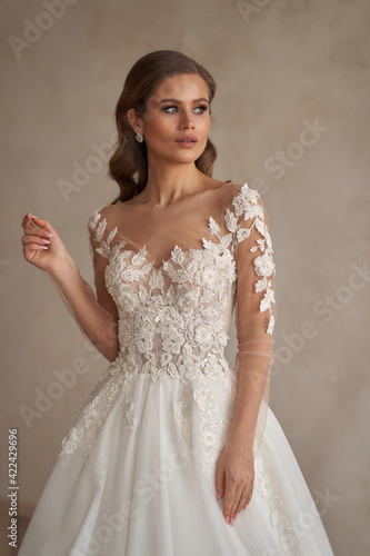 Portrait og young beautiful woman wearing white wedding bridel dress. Pretty slim bride with natural make-up and wavy hair