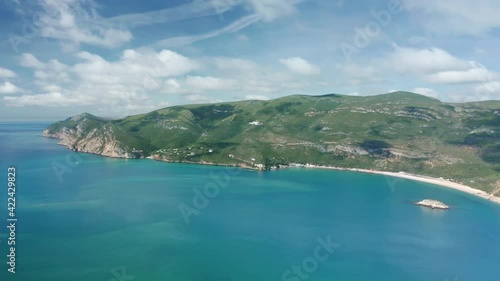 Beautiful natural scenery with steep hills and green shrubs. Aerial scenic view of the coastal part of Arrabida Natural Park, Portugal. High quality 4k footage