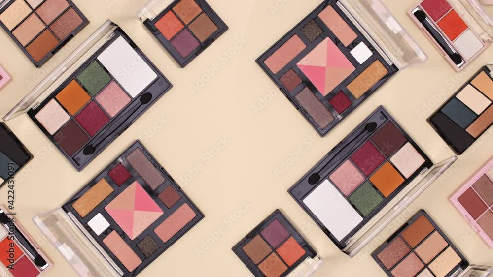Make up eye shadow palettes move on beige background with copy space. Stop motion Make up eye shadow palettes move on beige background with copy space. Stop motion