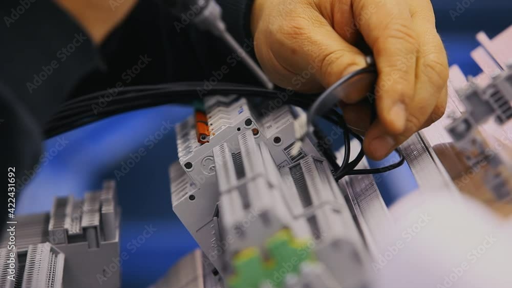 Worker's hands are screwing some connections to a patchbay Worker's hands are screwing some connections to a patchbay