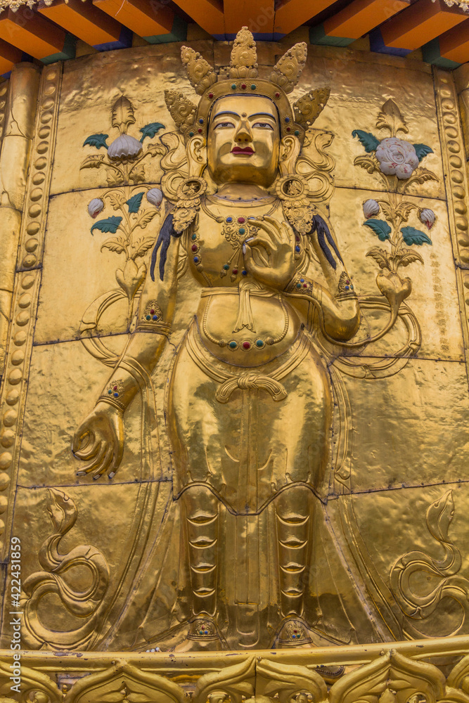 XIAHE, CHINA - AUGUST 25, 2018: Golden Buddha relief at Gongtang pagoda at Labrang monastery in Xiahe town, Gansu province, China