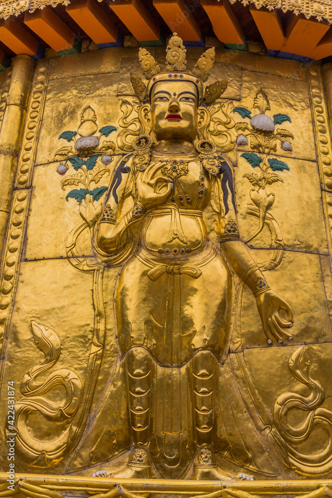XIAHE, CHINA - AUGUST 25, 2018: Golden Buddha relief at Gongtang pagoda at Labrang monastery in Xiahe town, Gansu province, China XIAHE, CHINA - AUGUST 25, 2018: Golden Buddha relief at Gongtang pagoda at Labrang monastery in Xiahe town, Gansu province, China