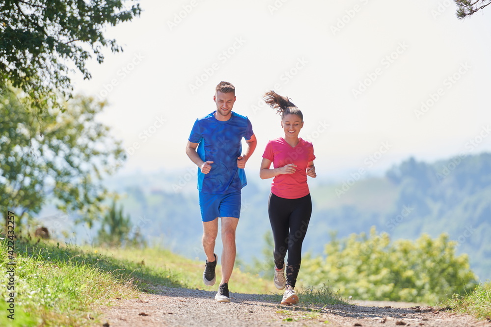 couple enjoying in a healthy lifestyle while jogging on a country road couple enjoying in a healthy lifestyle while jogging on a country road