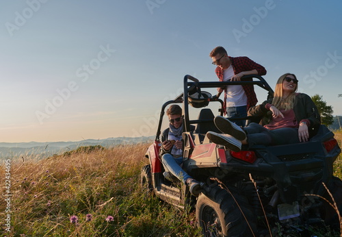group young happy people enjoying beautiful sunny day while driving a off road buggy car