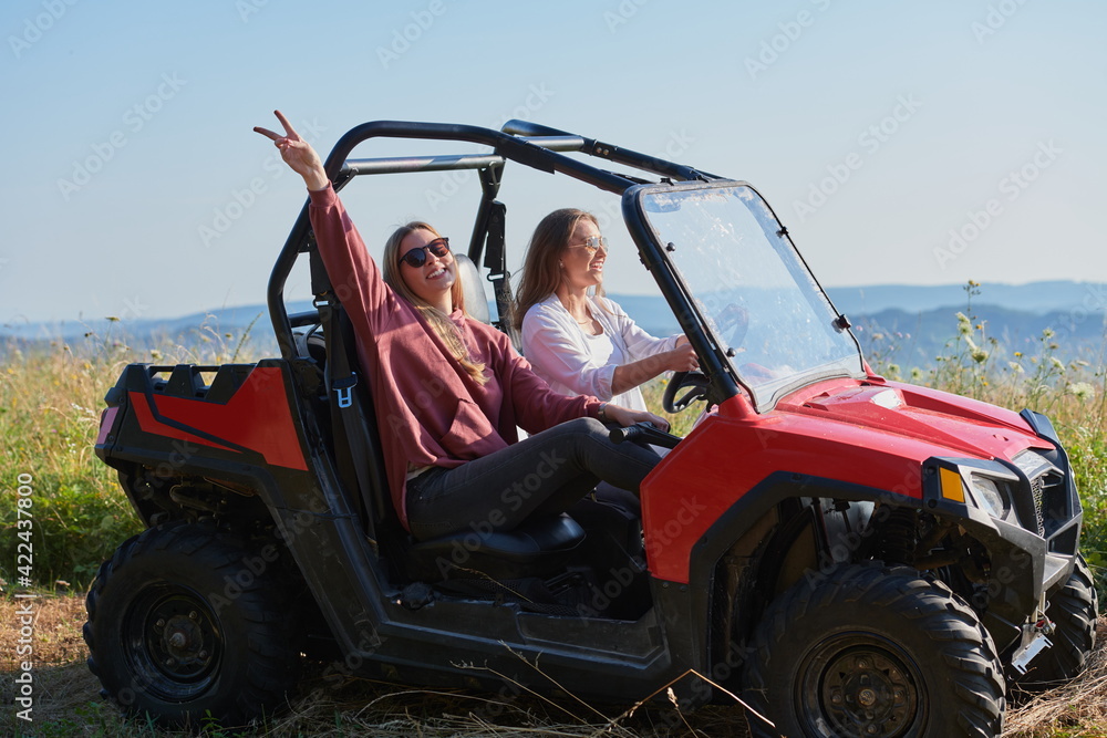 girls enjoying a beautiful sunny day while driving an off-road car girls enjoying a beautiful sunny day while driving an off-road car