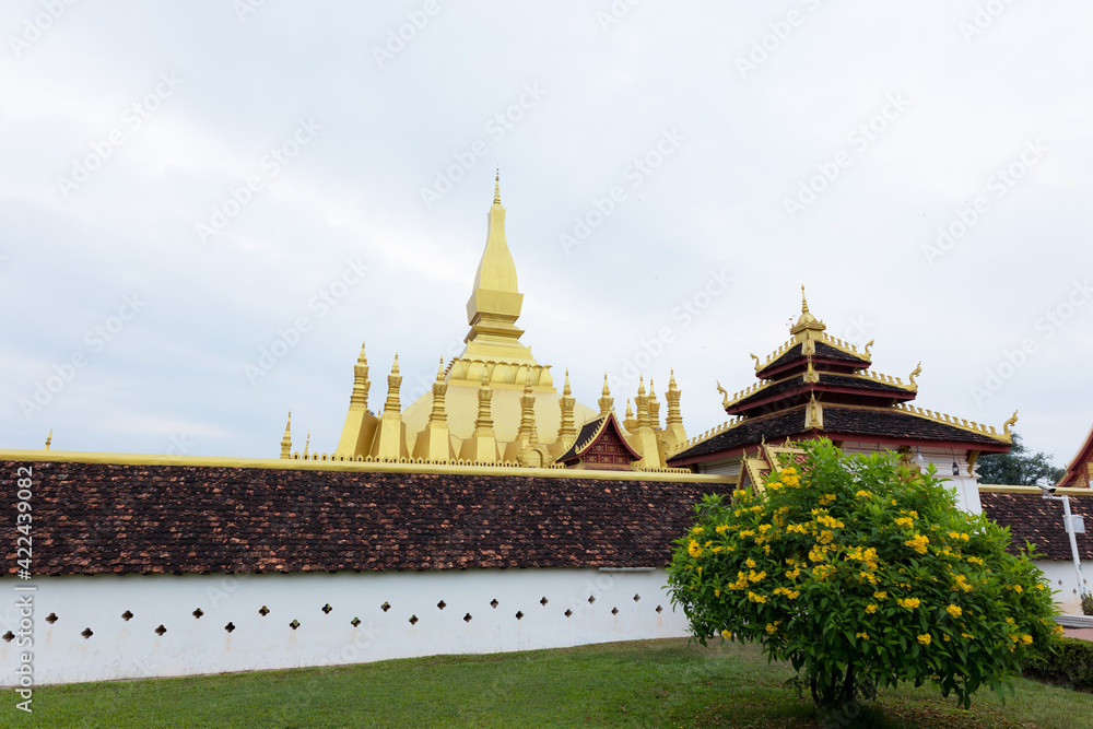 Naklejka premium Pha That Luang Vientiane, Laos. That-Luang Golden Pagoda in Vientiane, Laos. Pha That Luang at Vientiane. Blue sky background beautiful.