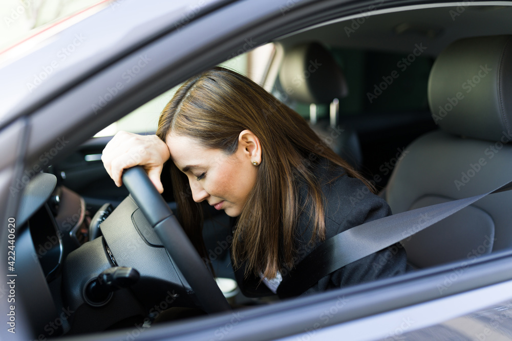 Stressed professional woman feeling overwhelmed in the car