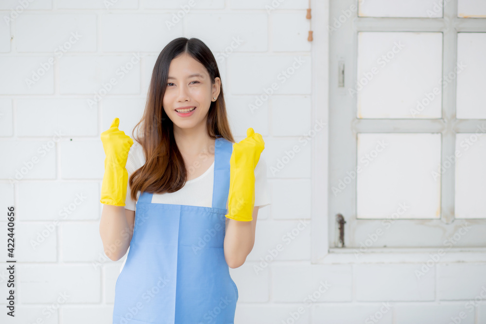 Portrait young asian woman is housekeeper in rubber gloves and apron for protection at home, uniform of maid, cleaning and washing, girl standing worker positive, one people, lifestyle concept. Portrait young asian woman is housekeeper in rubber gloves and apron for protection at home, uniform of maid, cleaning and washing, girl standing worker positive, one people, lifestyle concept.