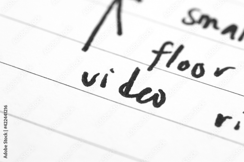 Macro shot of hand writing on paper using pen Macro shot of hand writing on paper using pen