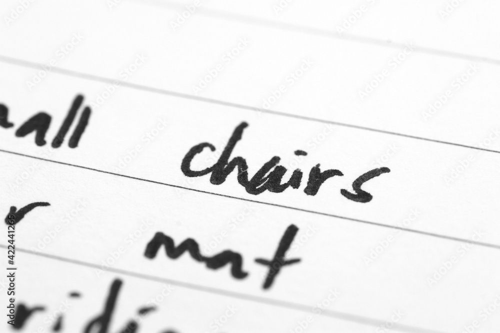 Macro shot of hand writing on paper using pen Macro shot of hand writing on paper using pen