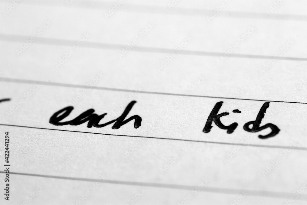 Macro shot of hand writing on paper using pen Macro shot of hand writing on paper using pen