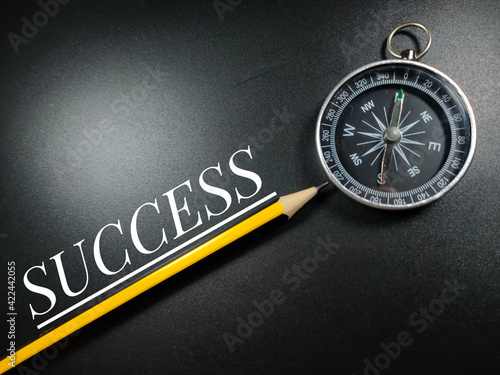 Business concept.Text SUCCESS with pencil and compass on black background.