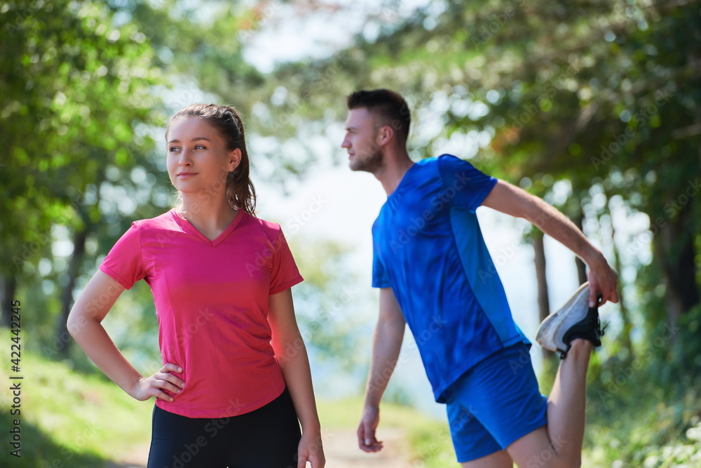 couple enjoying in a healthy lifestyle warming up and stretching before jogging couple enjoying in a healthy lifestyle warming up and stretching before jogging