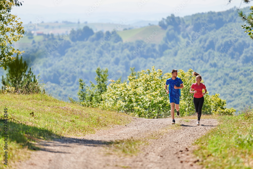 couple enjoying in a healthy lifestyle while jogging on a country road