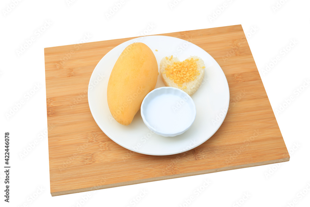 Golden mango and sticky rice served with coconut cream on white circle ceramic plate on bamboo board background. Tropical summer fruit in thailand Golden mango and sticky rice served with coconut cream on white circle ceramic plate on bamboo board background. Tropical summer fruit in thailand