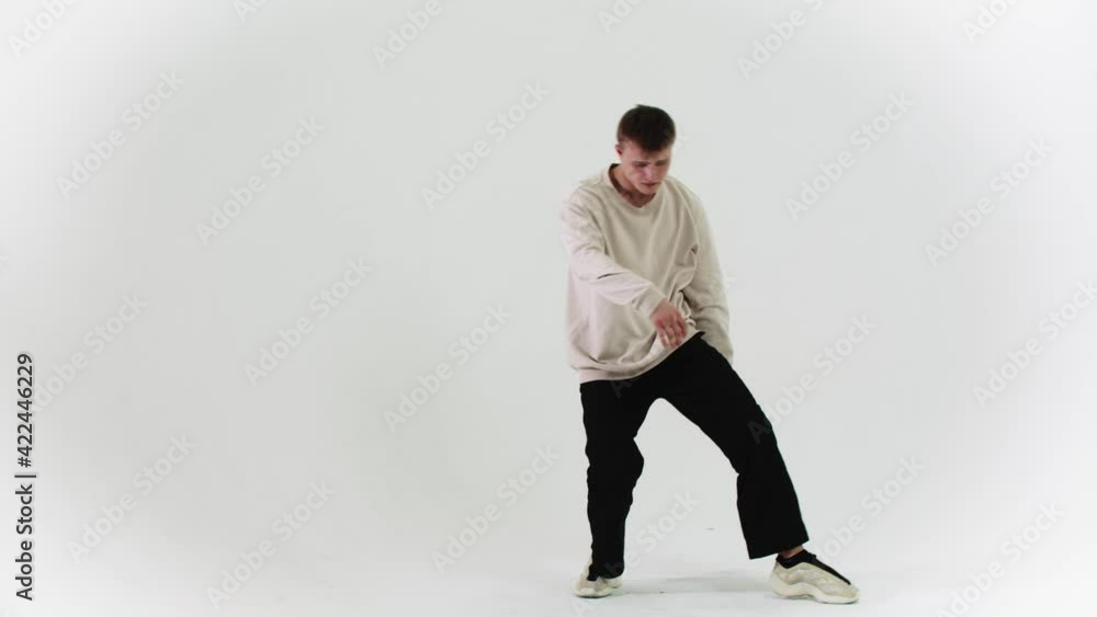 Young stylish man dancing on white cyclorama in the studio Young stylish man dancing on white cyclorama in the studio