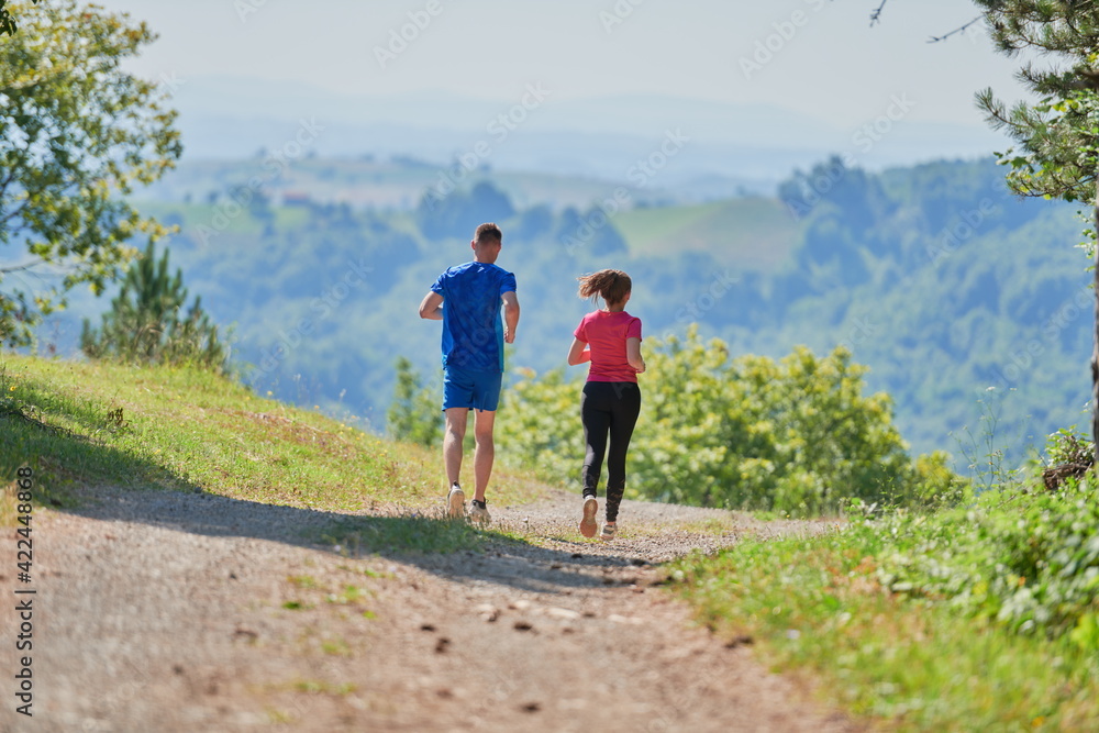 couple enjoying in a healthy lifestyle while jogging on a country road