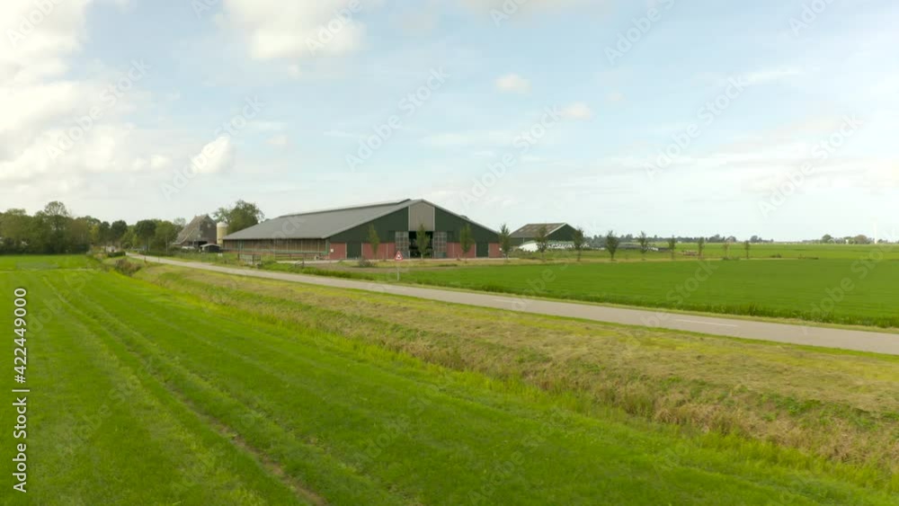 Drone shot a dutch farm surrounded by trees and grassland on a sunny day Drone shot a dutch farm surrounded by trees and grassland on a sunny day
